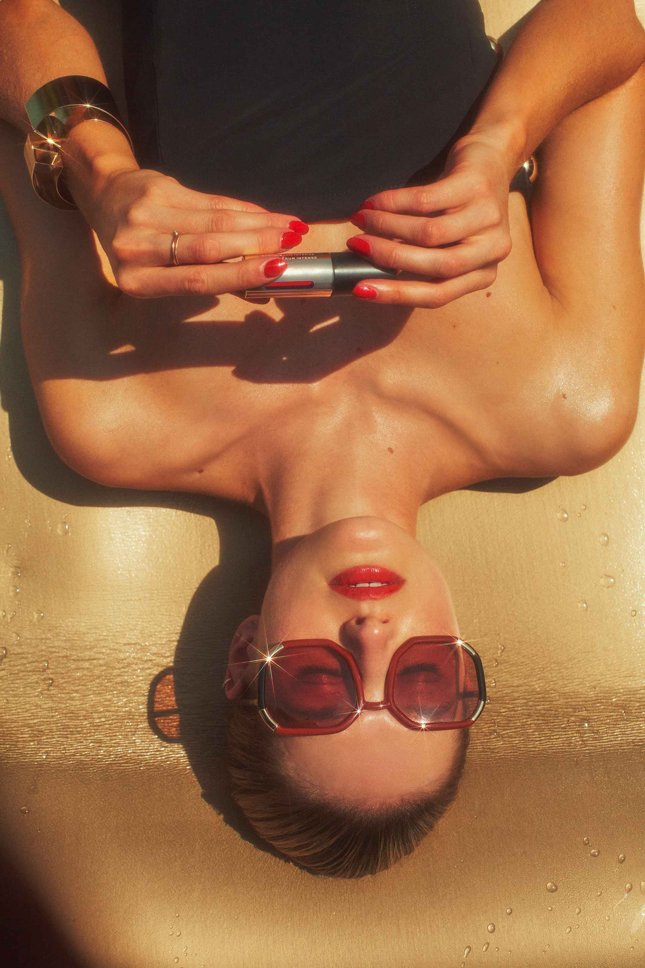 model sunbathing with sunglasses on